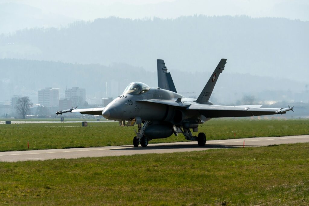 a fighter jet sitting on top of an airport runway