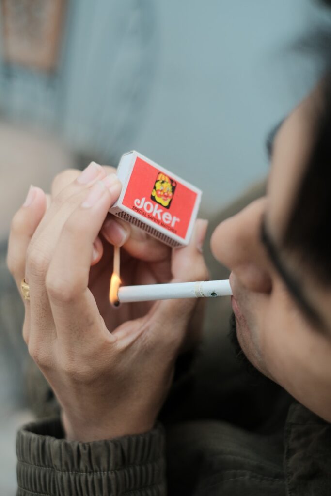 a man smoking a cigarette and holding a cigarette lighter